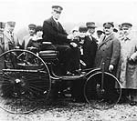 Karl Benz auf dem Patent-Motorwagen im Jahre 1925, w�hrend der Verkehrsaustellung in M�nchen auf der Theresienwiese.
